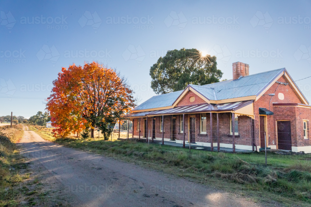 An old brick railway building with an autumn tree - Australian Stock Image