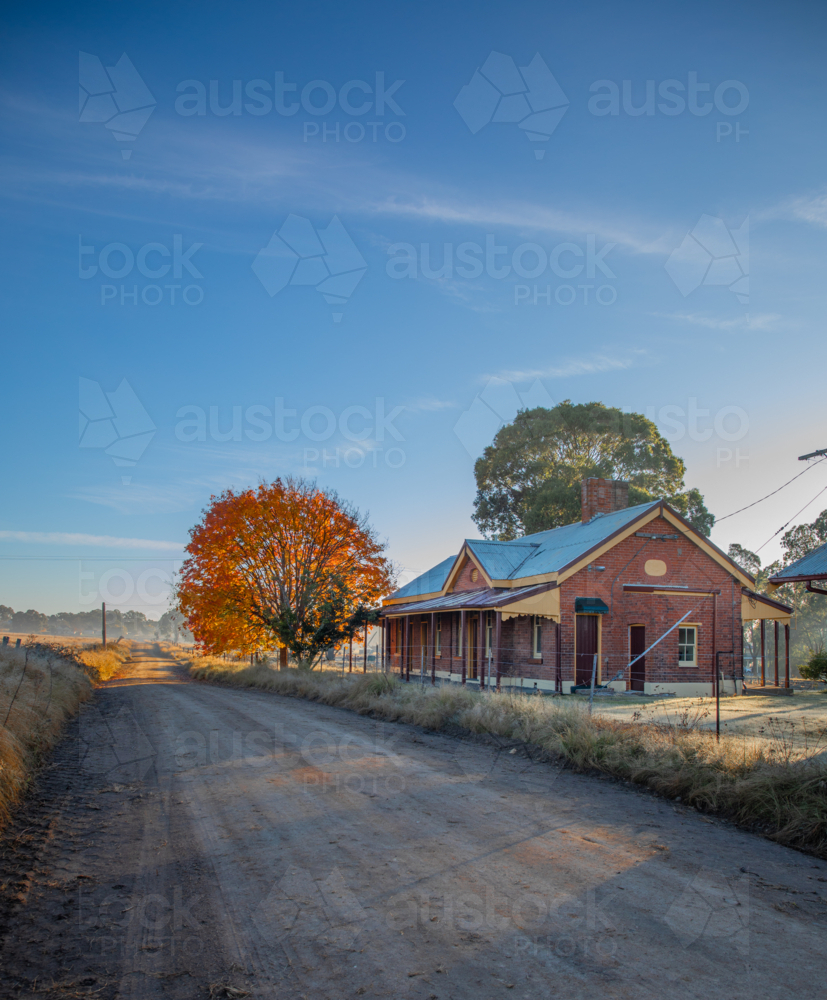 An old country brick building, an autumn tree and a blue sky - Australian Stock Image
