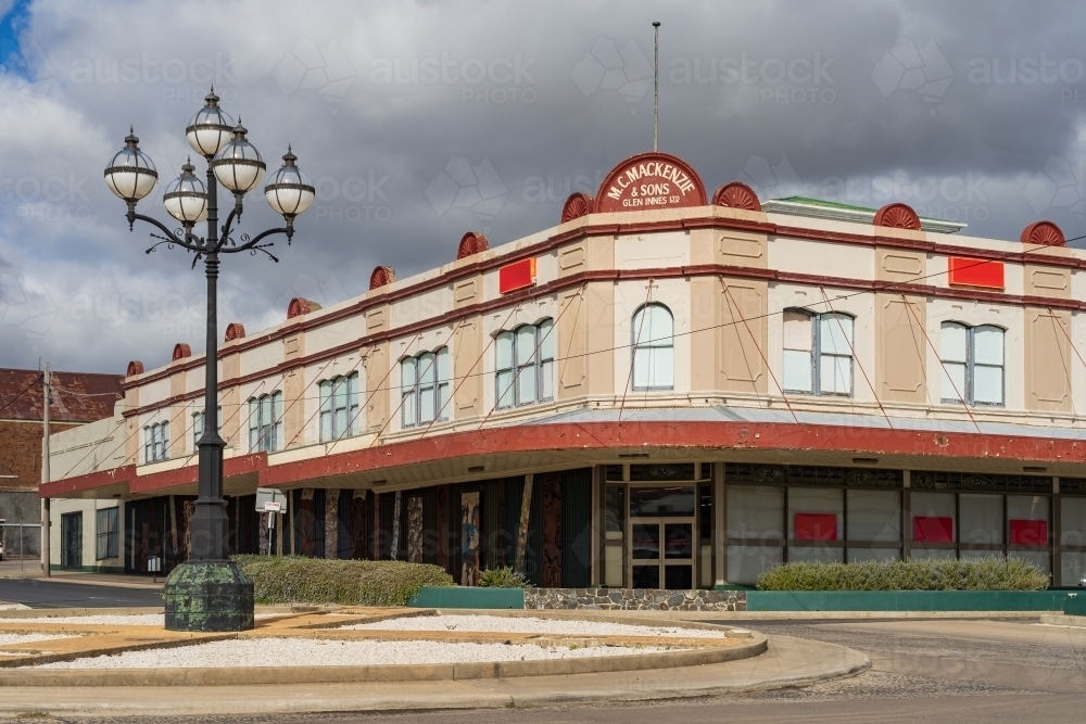 An old fashioned department store building with wide verandas alongside a roundabout - Australian Stock Image