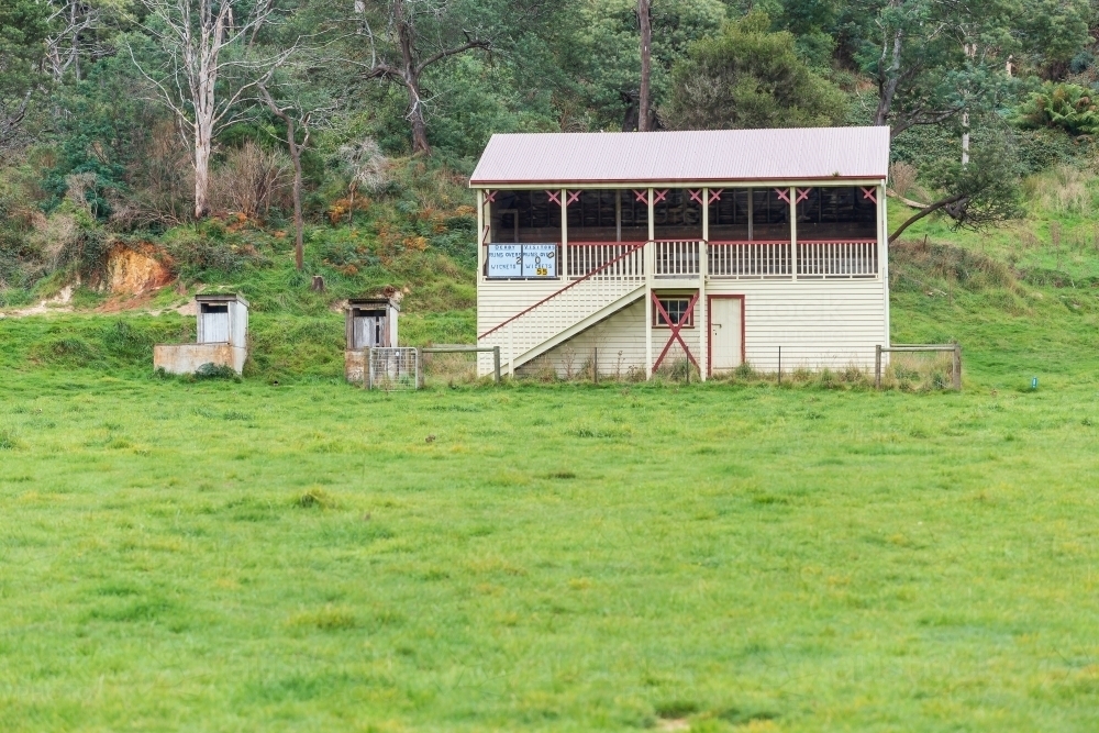 An old fashioned grandstand on the edge of an overgrown oval - Australian Stock Image