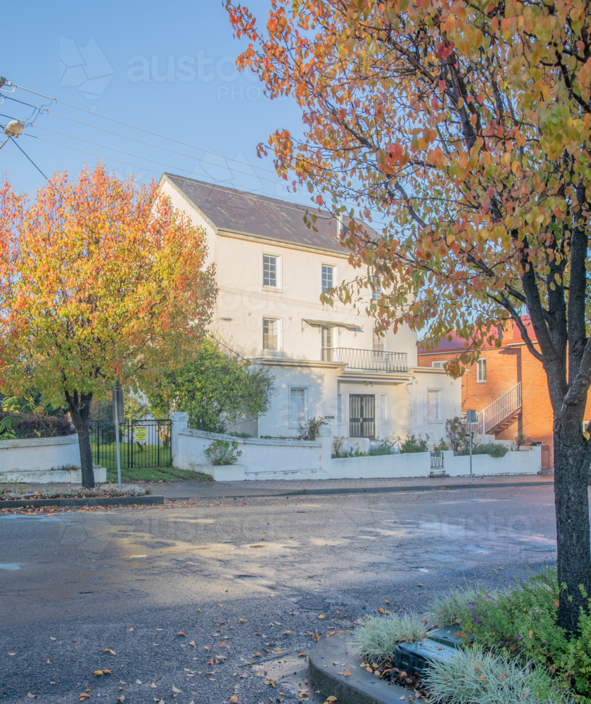 An old mill house building, framed by autumn leaves - Australian Stock Image