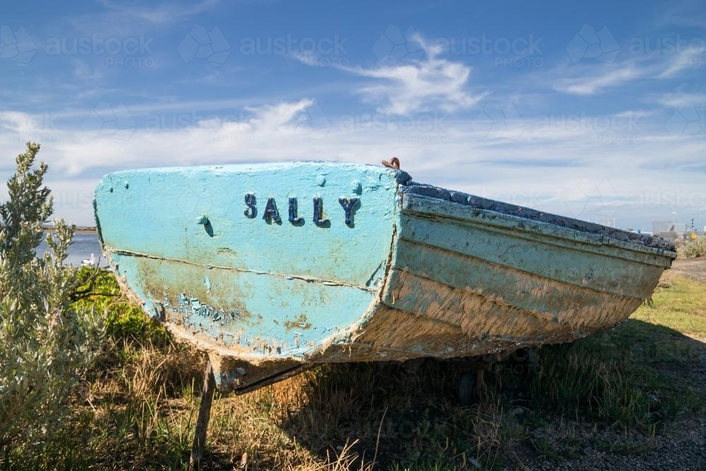 An old row boat sitting on the shoreline - Australian Stock Image