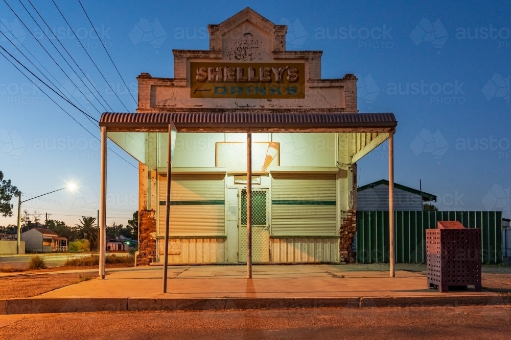Image of An old style corner milk bar with a veranda at twilight under