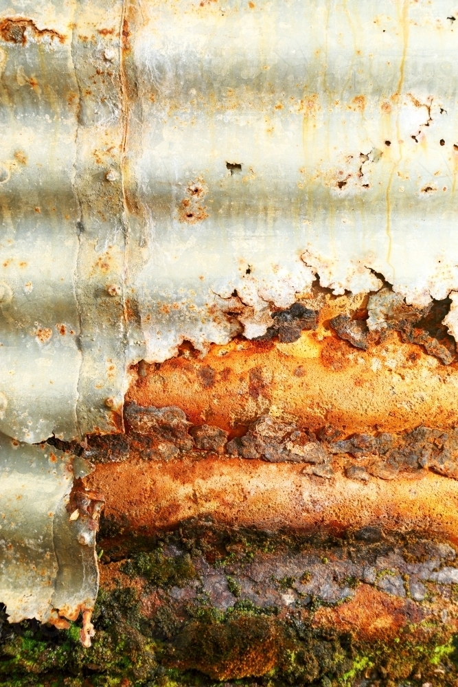 An old water tank rusting and leaking after a long life. - Australian Stock Image