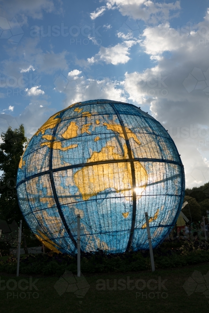 An outdoor display of the globe featuring Australia with the sun shining through - Australian Stock Image