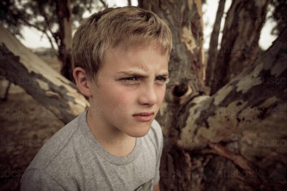 Angry boy in the bush - not smiling - Australian Stock Image