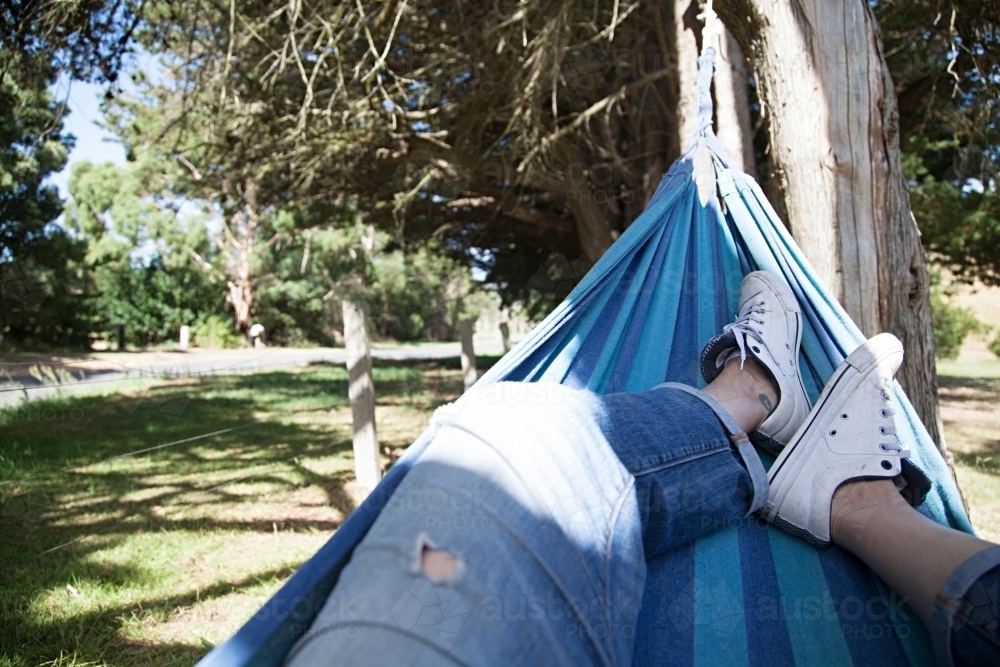 Anonymous woman's leg lazing in a hammock - Australian Stock Image