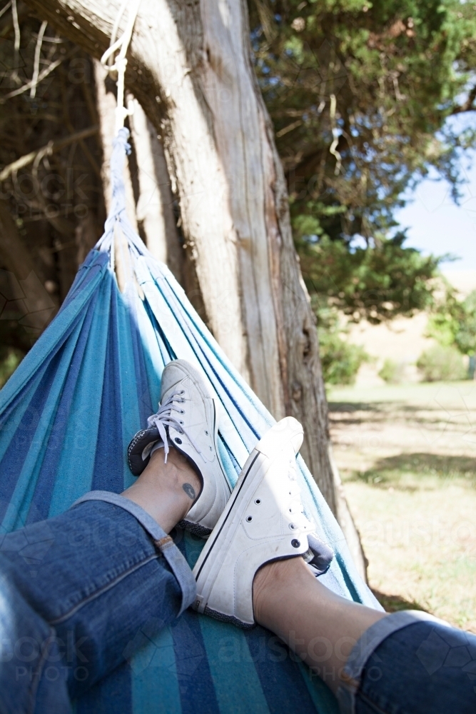 Anonymous woman's leg lazing in a hammock - Australian Stock Image