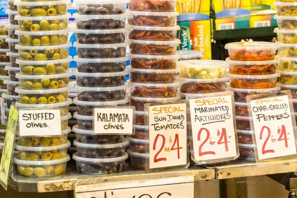 Antipasto ingredients stacked in plastic containers for sale at a market - Australian Stock Image