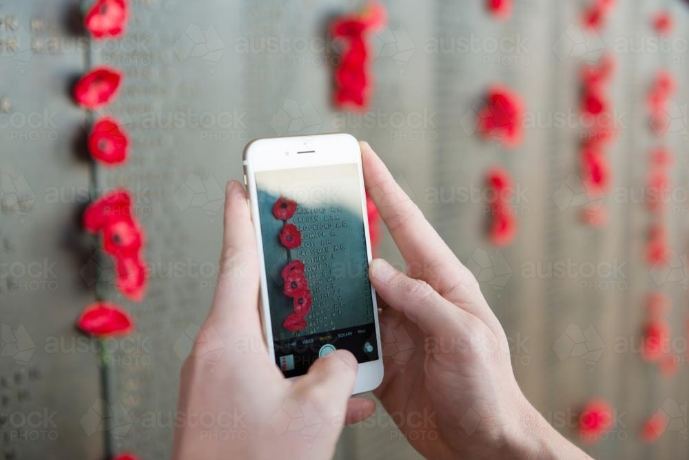 ANZAC DAY at the Australian War Memorial phone taking a photo of the wall - Australian Stock Image