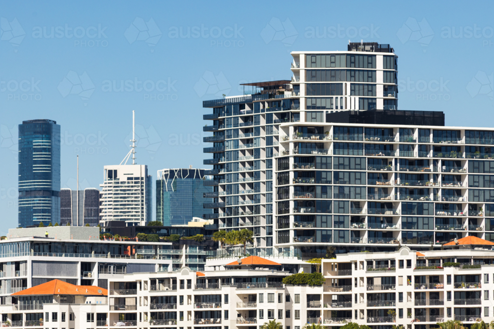 Apartment buildings adjacent to the Brisbane River with skyscrapers in the background - Australian Stock Image