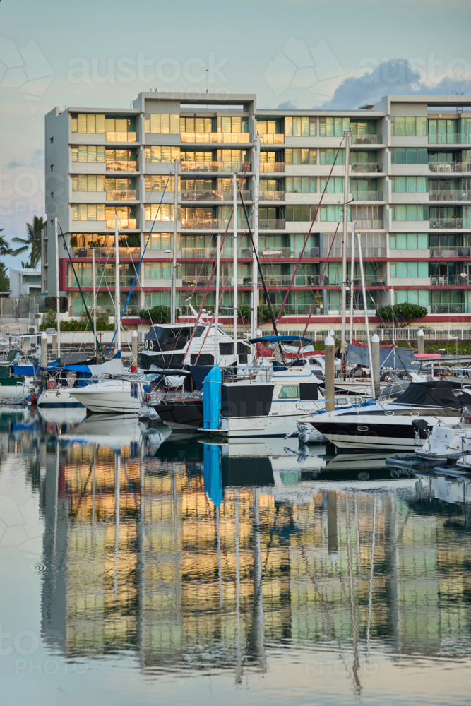 Apartments reflected in water of marina with boats - Australian Stock Image