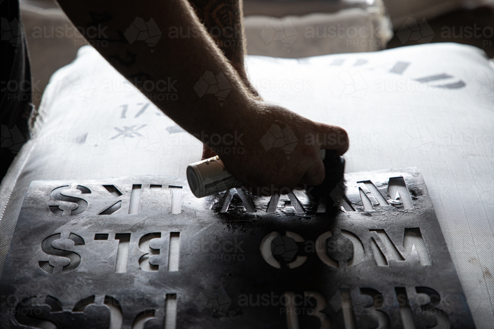 Applying a stencil to a bale of wool - Australian Stock Image