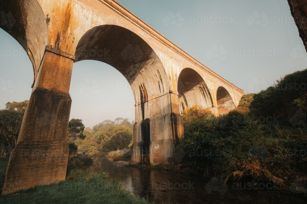 Archways of historic bridges over tranquil creek in the Blue Mountains - Australian Stock Image