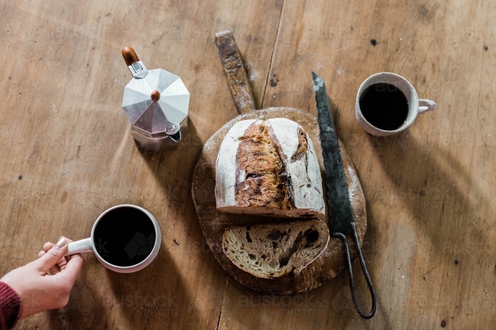 Artisan bread and stovetop espresso maker and coffee cups from above - Australian Stock Image