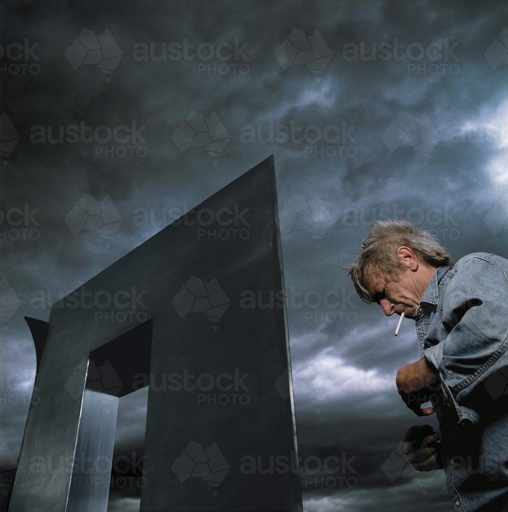 Artist and sculpture with stormy sky - Australian Stock Image