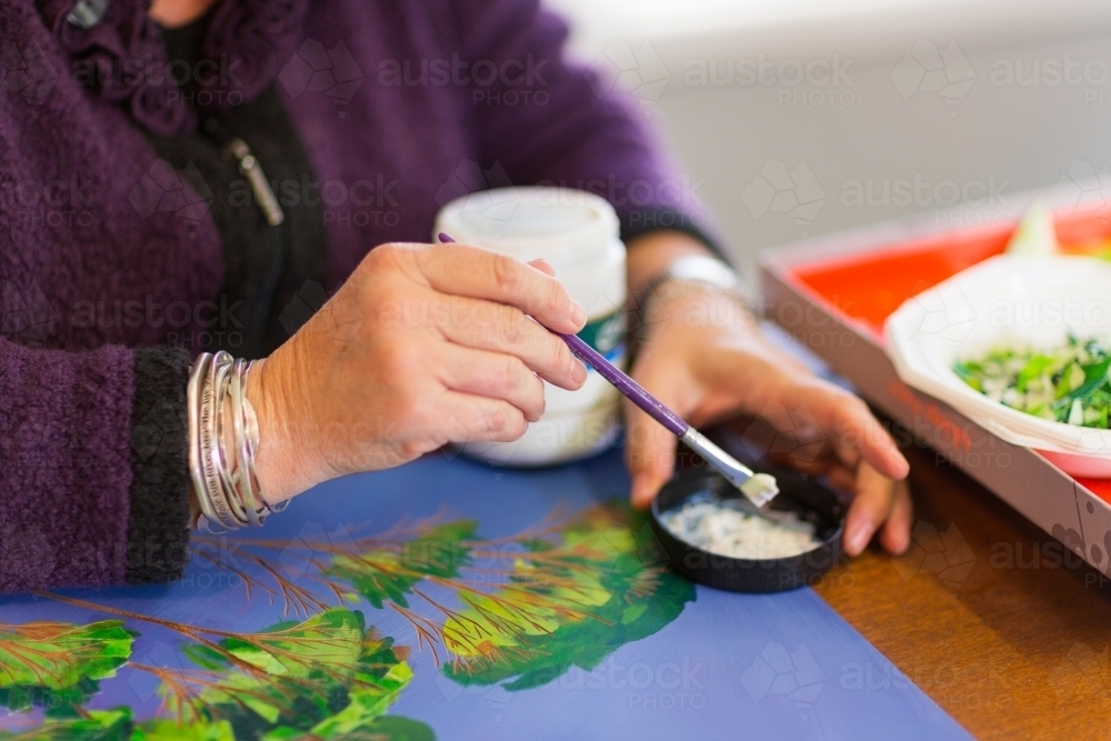 Artist's hands with brush and artwork - Australian Stock Image