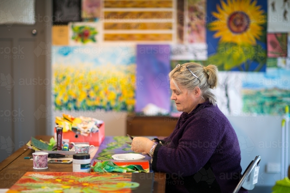 Artist working in colourful studio - Australian Stock Image