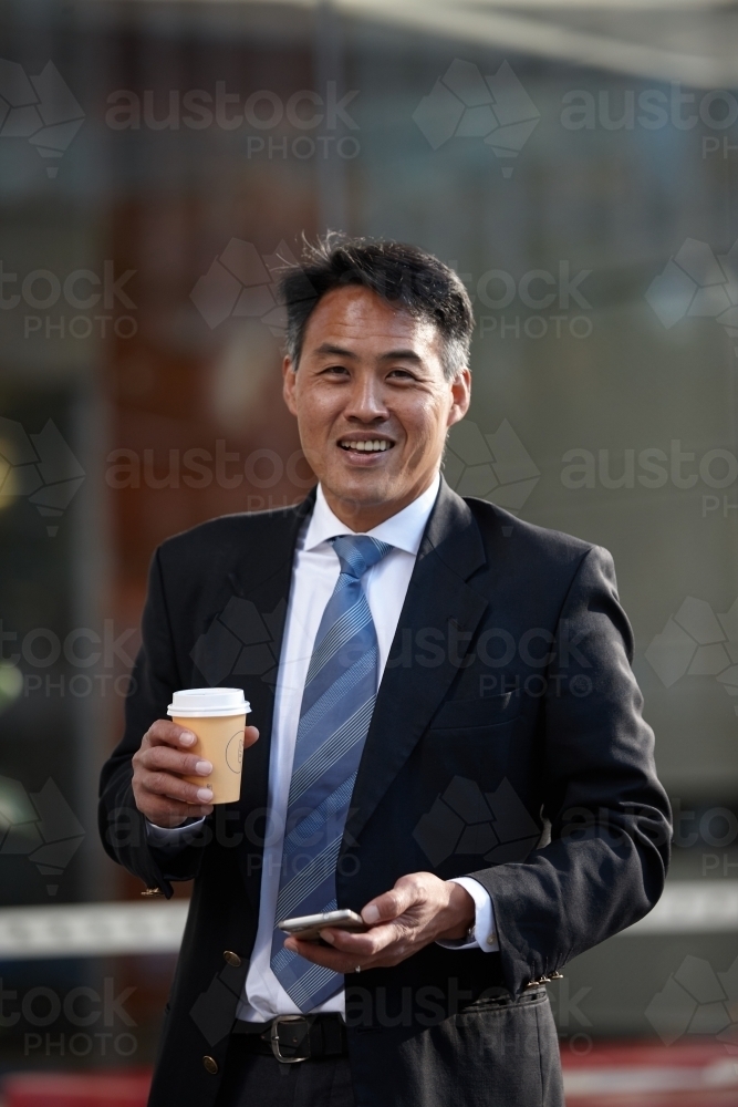 Asian businessman in city - Australian Stock Image