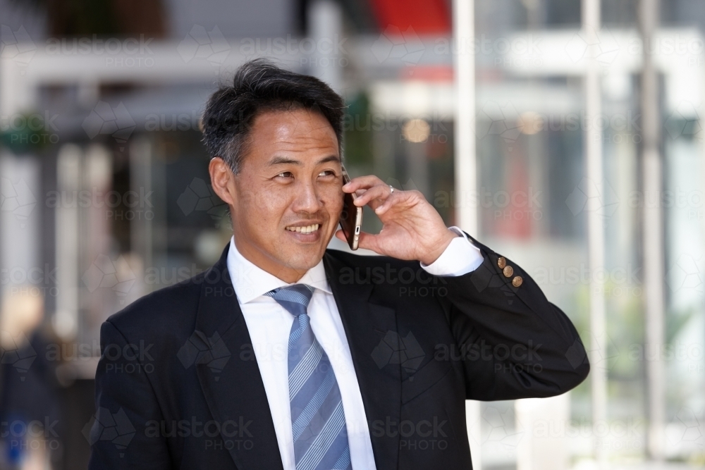 Asian businessman in city - Australian Stock Image