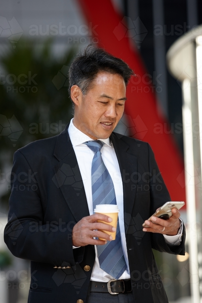 Asian businessman in city - Australian Stock Image