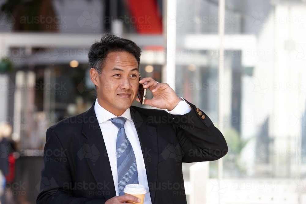 Asian businessman in city - Australian Stock Image