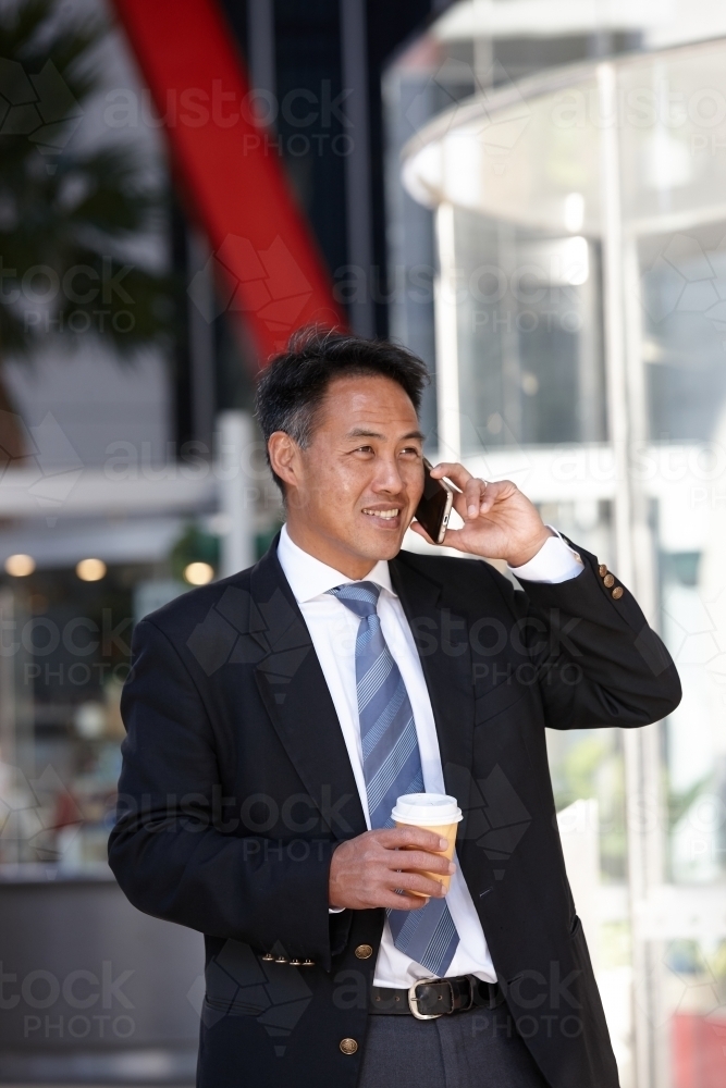 Asian businessman in city - Australian Stock Image