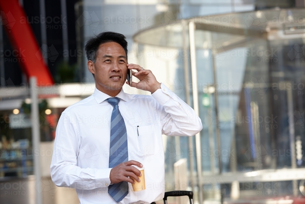 Asian businessman in city - Australian Stock Image
