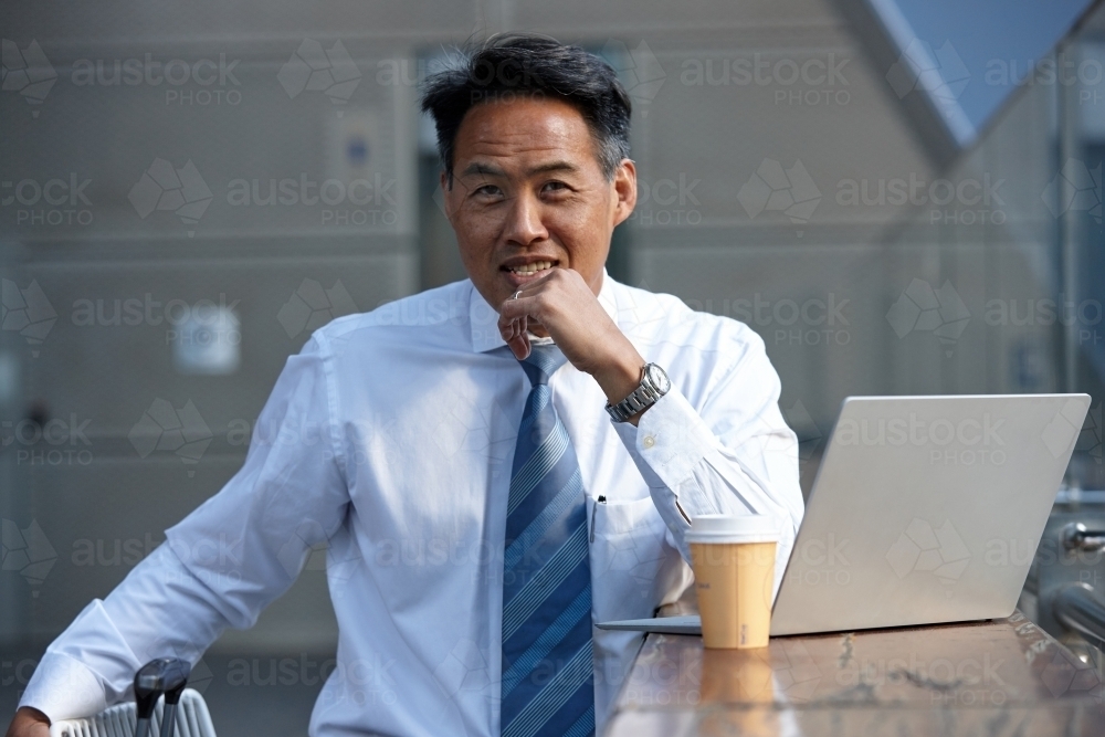 Asian businessman in city - Australian Stock Image