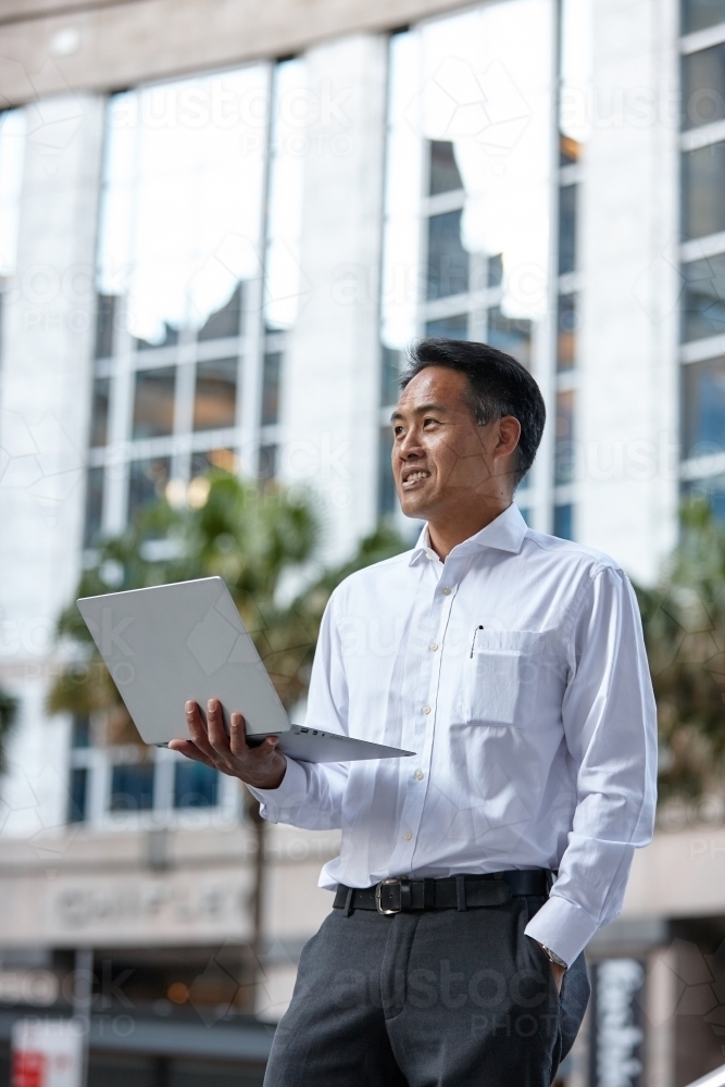 Asian businessman in city - Australian Stock Image