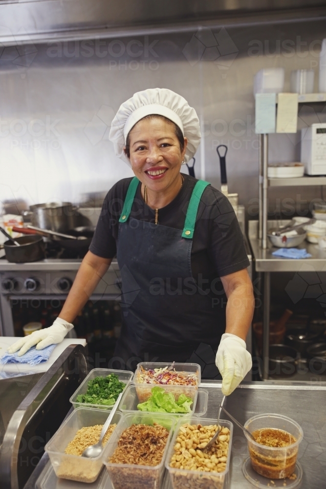 Asian female chef in commercial kitchen - Australian Stock Image