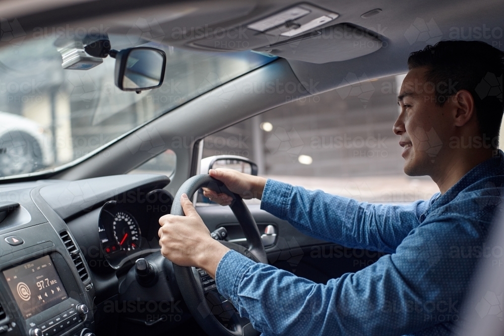 Asian man driving in car - Australian Stock Image