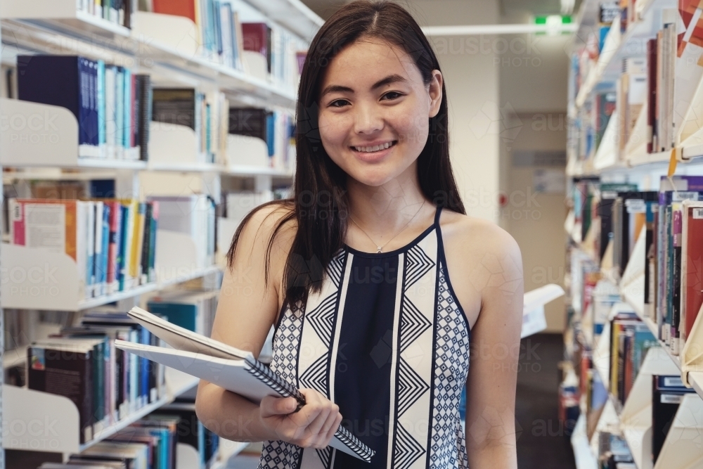 Asian students in university library - Australian Stock Image
