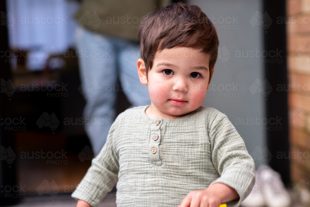 asian toddler, with mum in the background - Australian Stock Image
