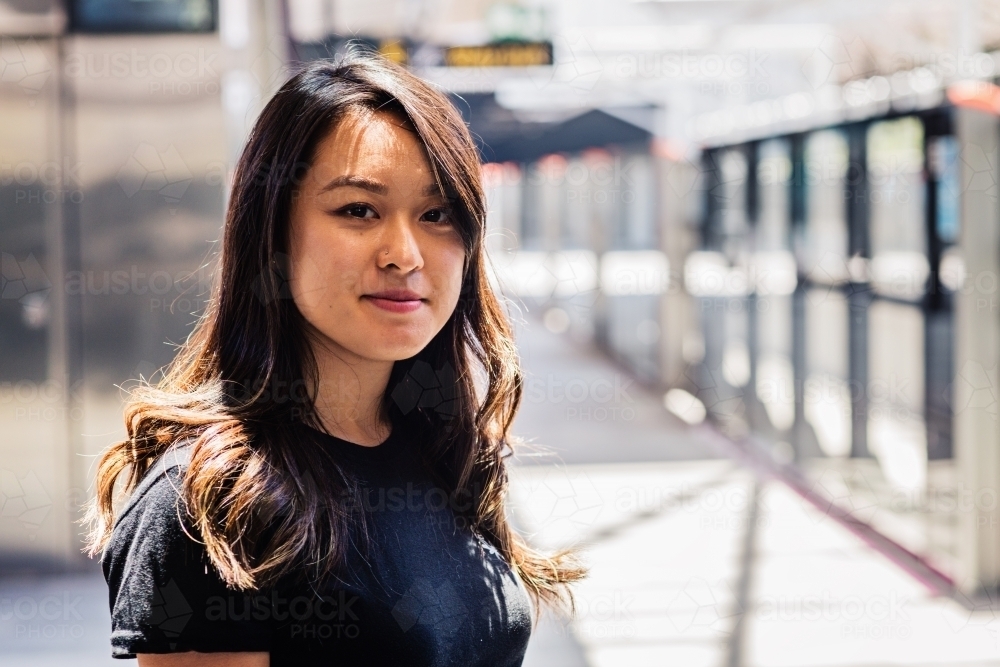 asian woman at train station - Australian Stock Image