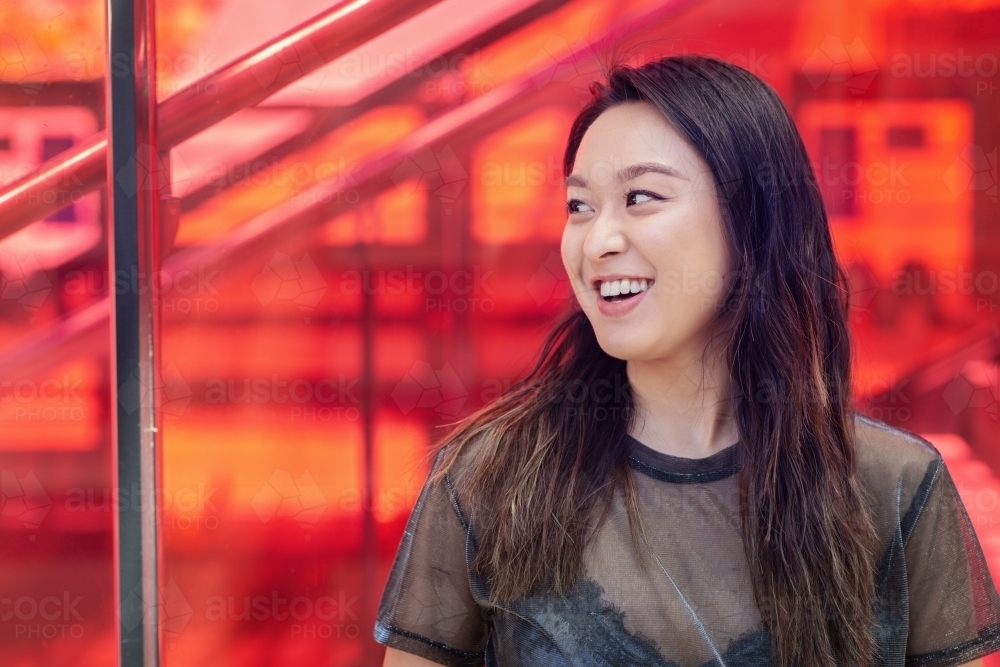 asian woman smiling at friend - Australian Stock Image