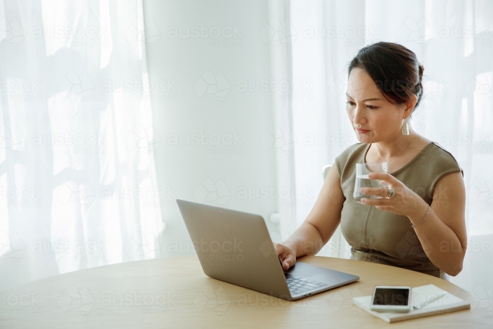 Asian woman working on a computer - Australian Stock Image