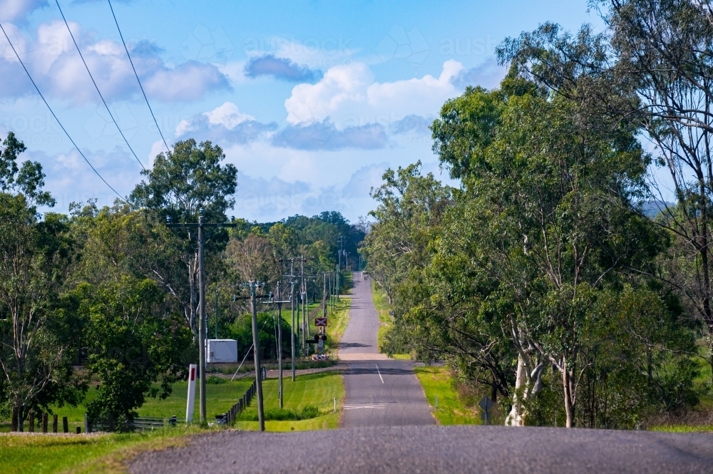 Asphalt country road with telephone poles and lines - Australian Stock Image