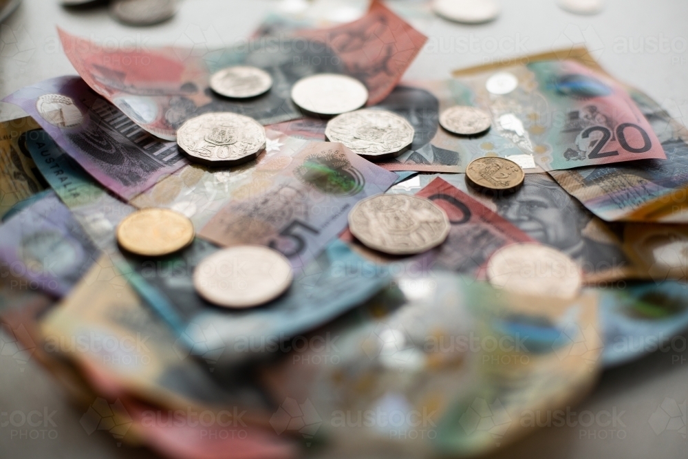 assorted Australian currency including notes and coins on a benchtop - Australian Stock Image