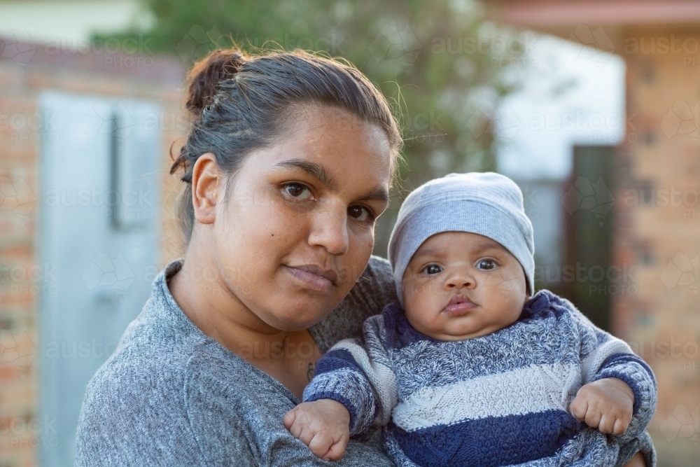 Attractive young mother holding her baby outside - Australian Stock Image