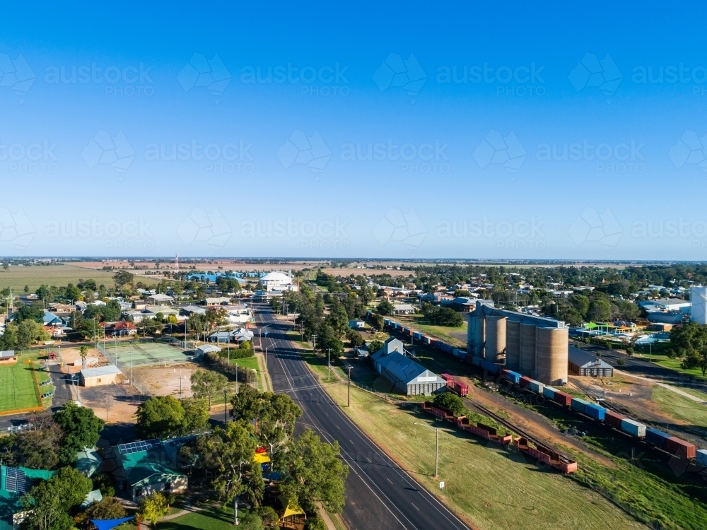 Aussie country town scene in Narromine of grain silos beside railway and freight train - Australian Stock Image