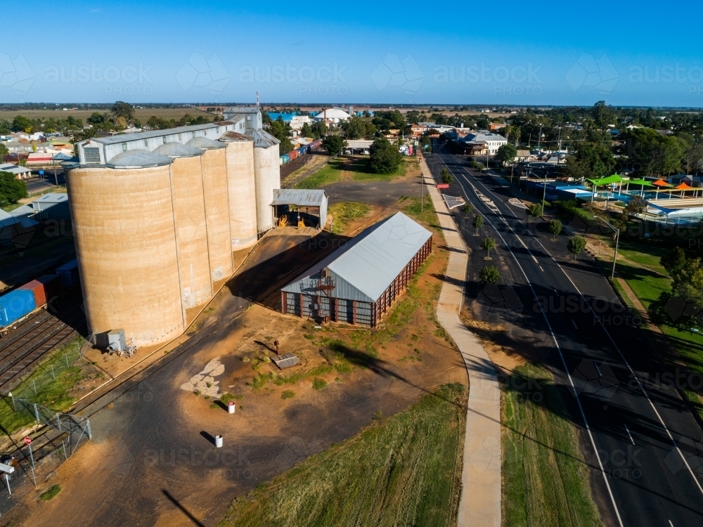 Aussie country town scene in Narromine of grain silos beside railway and freight train - Australian Stock Image