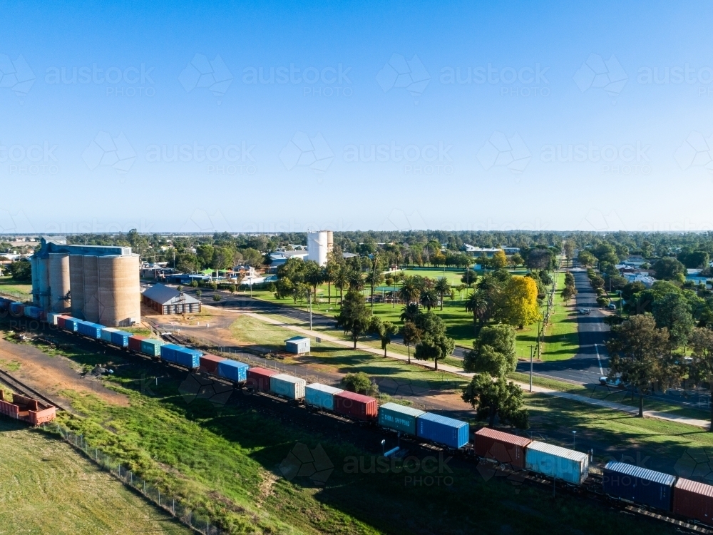 Aussie country town scene in Narromine of grain silos beside railway and freight train - Australian Stock Image