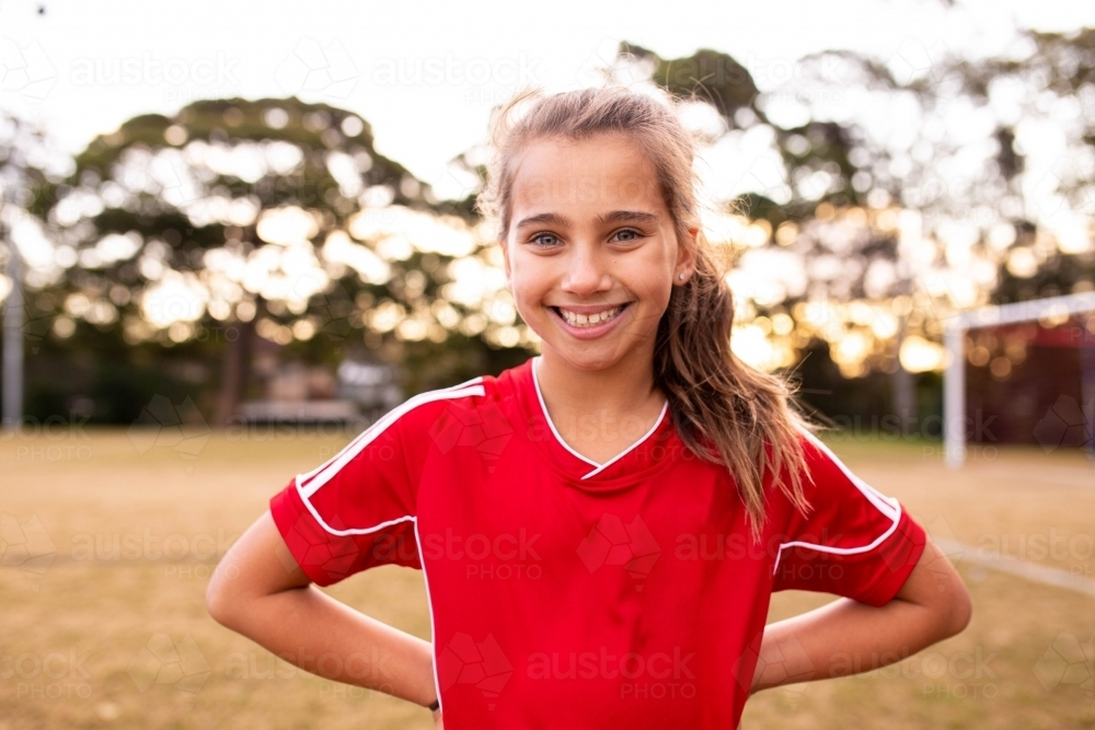 Aussie soccer player girl smiling confidently with hands on her back - Australian Stock Image