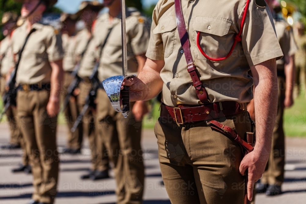 Australian army soldier with sword drawn for Freedom of Entry ceremony beside troops - Australian Stock Image