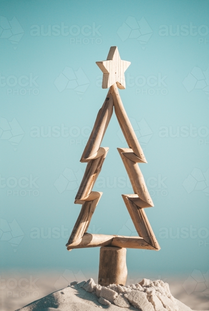 Australian Christmas.  Driftwood timber Christmas tree in sand by the ocean - Australian Stock Image