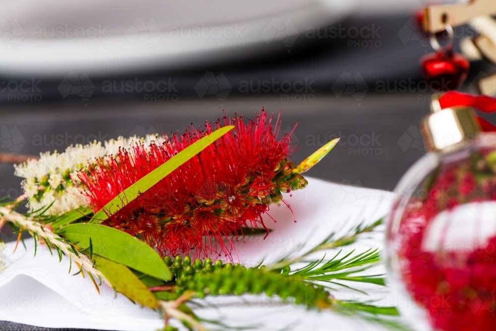 Australian christmas theme table with red native bottlebrush flower, focus on the flower - Australian Stock Image