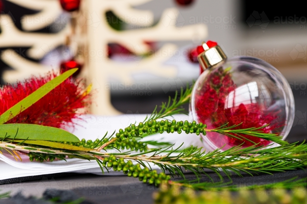 Australian christmas theme table with red native bottlebrush flower in a glass ornament - Australian Stock Image