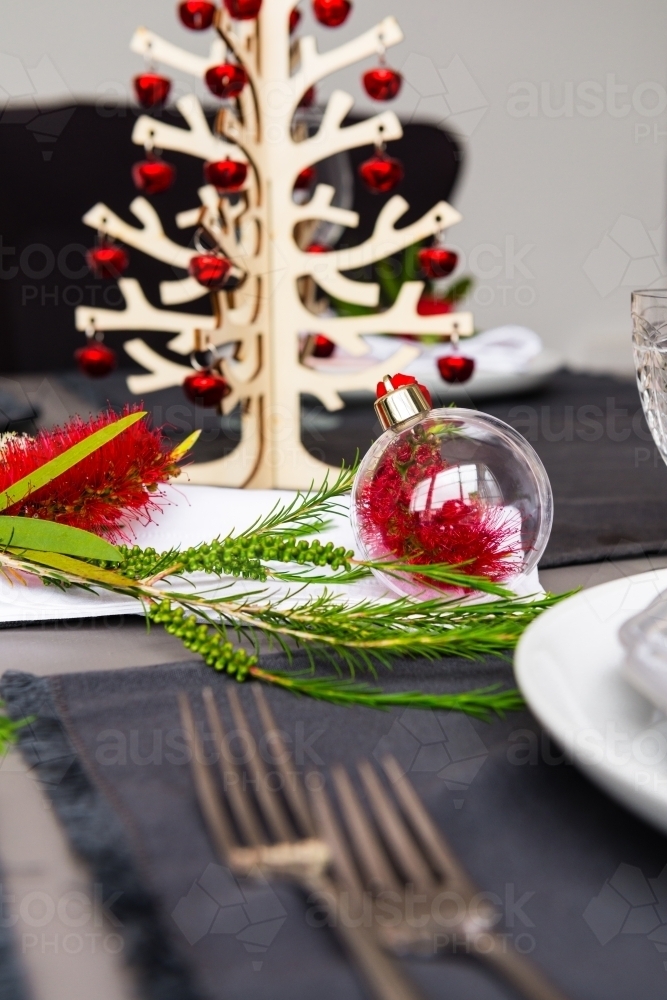 Australian christmas theme table with red native bottlebrush flower, with small christmas tree - Australian Stock Image