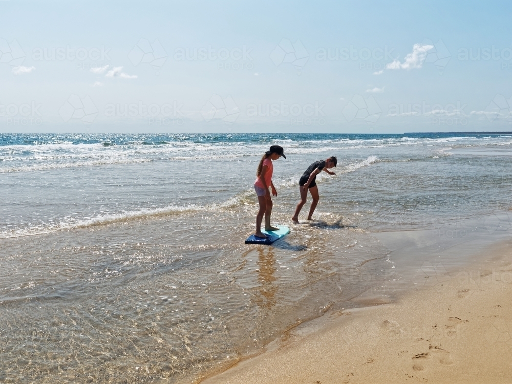 Australian coastal living boy and girl playing on the beach - Australian Stock Image